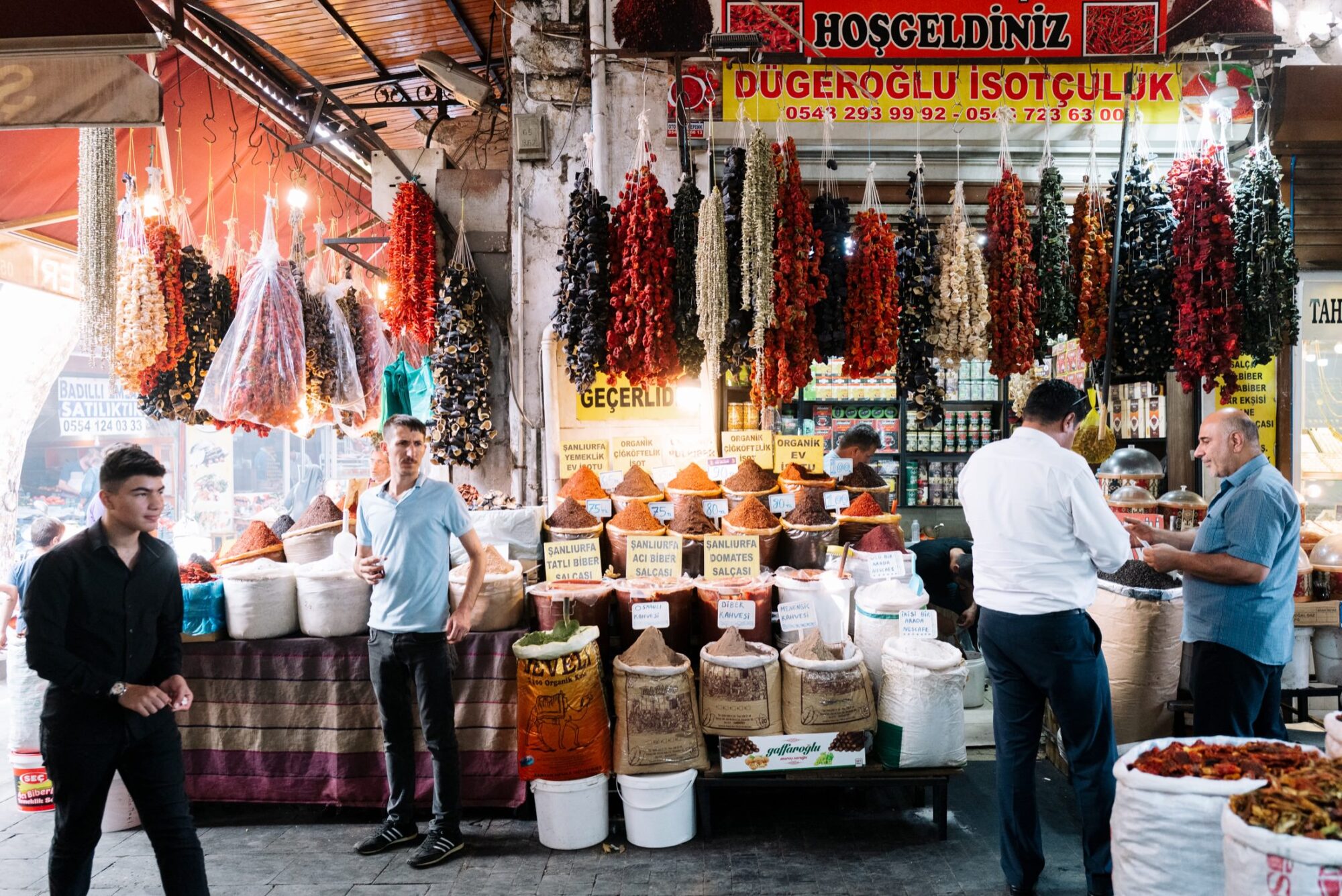 Seattle's best commercial food and hospitality photographer A vibrant spice market with sacks of spices, piles of dried goods, and strings of dried peppers and vegetables hanging above—captured by Seattles best commercial food lifestyle photographer as people browse the colorful display. captured by seattle's best food and lifestyle photographer Brooke Fitts