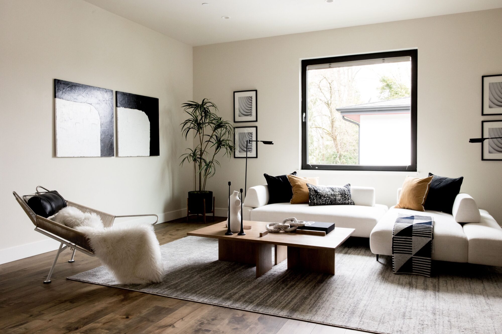 Seattle's best commercial food and hospitality photographer A modern living room with a white sofa, neutral cushions, a wooden coffee table, and abstract wall art—captured beautifully by Seattles best commercial food lifestyle photographer, with natural light streaming through a large window. captured by seattle's best food and lifestyle photographer Brooke Fitts