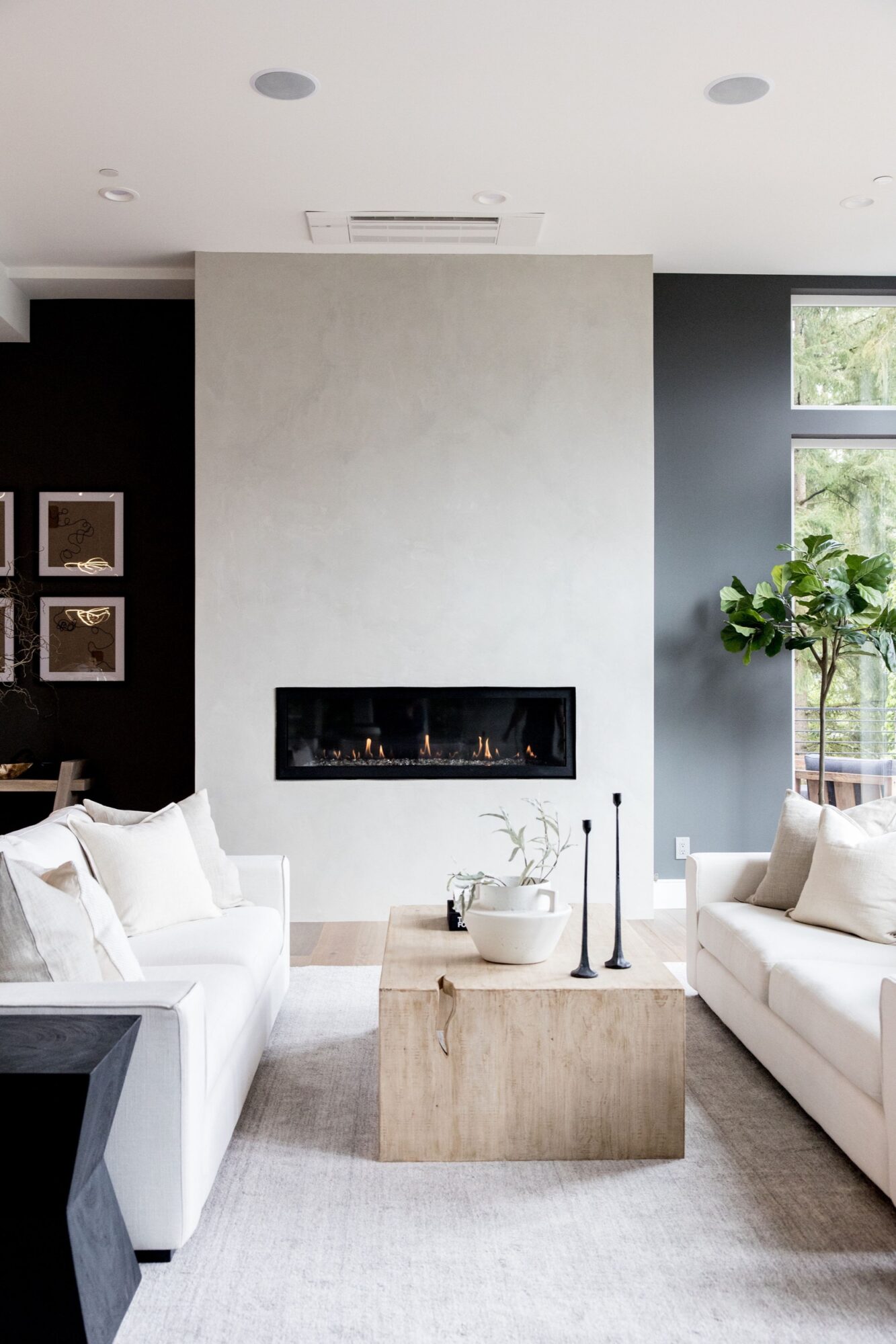 Seattle's best commercial food and hospitality photographer A modern living room with white sofas, a light wood coffee table, and a minimalist fireplace set in a gray wall is beautifully captured by Seattles best commercial food lifestyle photographer, with natural light streaming in through tall windows. captured by seattle's best food and lifestyle photographer Brooke Fitts