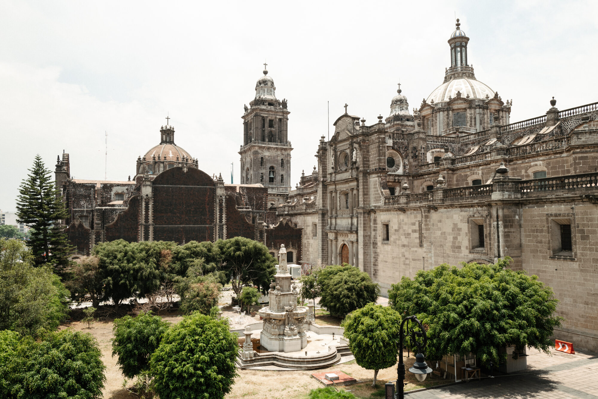 Seattle's best commercial food and hospitality photographer A historic cathedral with tall domes and towers stands behind a garden with green trees and a white stone fountain under a partly cloudy sky, beautifully captured by Seattles best commercial food lifestyle photographer. captured by seattle's best food and lifestyle photographer Brooke Fitts