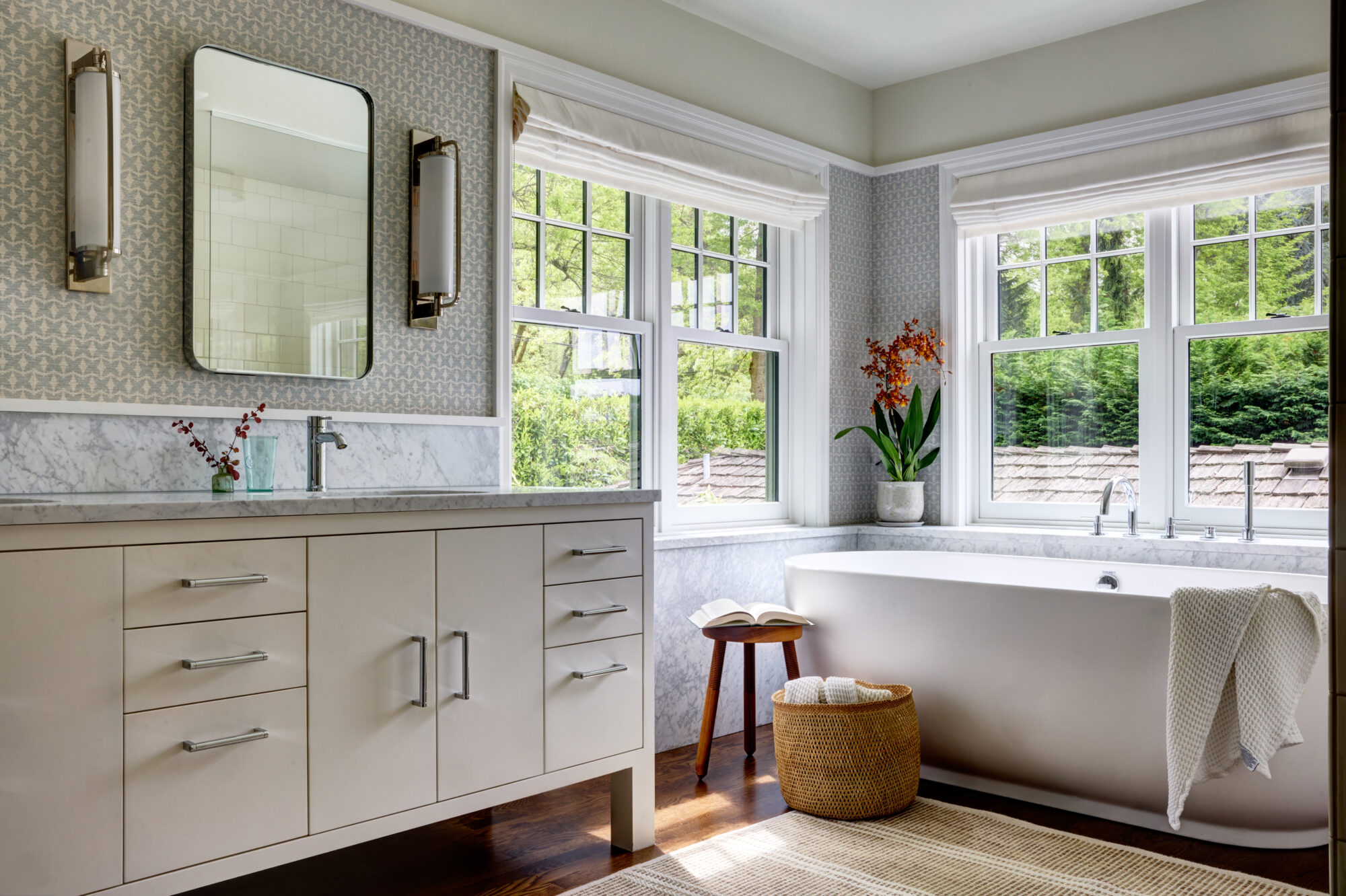 Seattle's best commercial interiors and hospitality photographer Bright, modern bathroom with large windows, a marble-topped vanity, rectangular mirror, and bathtub by the window—styled to perfection by a Seattle commercial interior design photographer for restaurants and hotels. captured by seattle's best food and lifestyle photographer Brooke Fitts