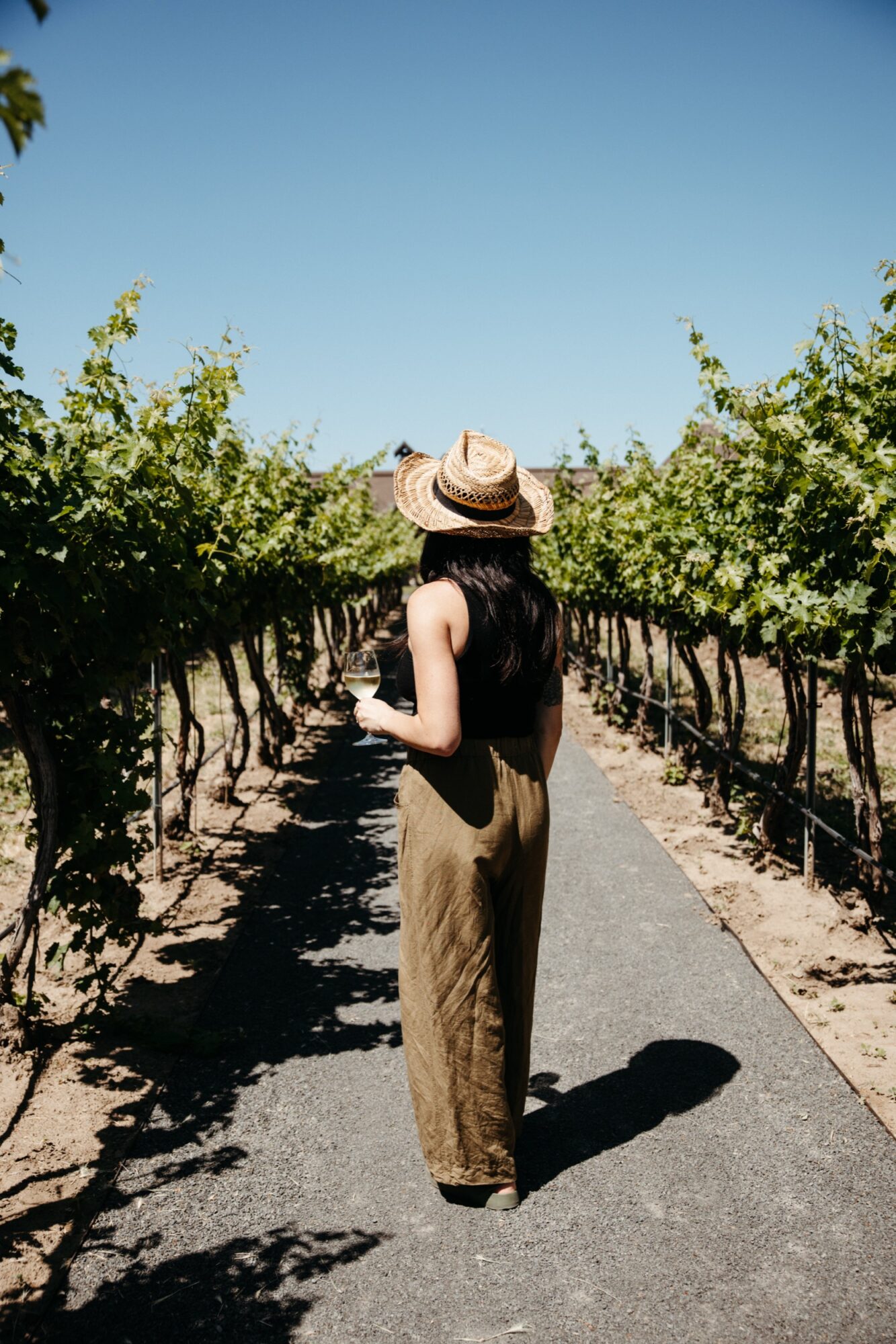 Seattle's best lifestyle potrait photographer A woman wearing a hat and holding a glass of wine. captured by seattle's best food and hospitality photographer Brooke Fitts