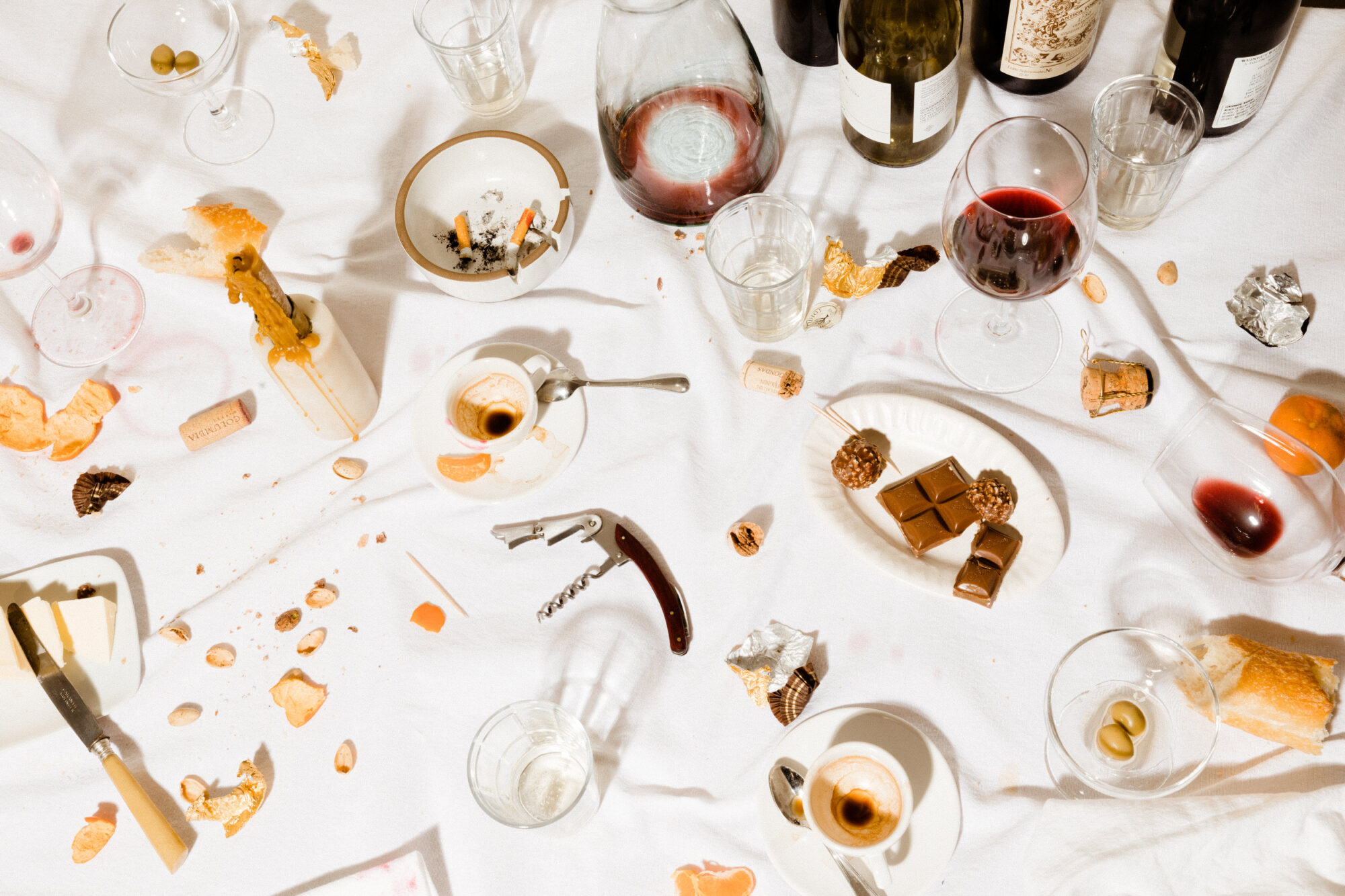 A table with empty wine glasses and bottles of alcohol. captured by seattle's best food and hospitality photographer Brooke Fitts